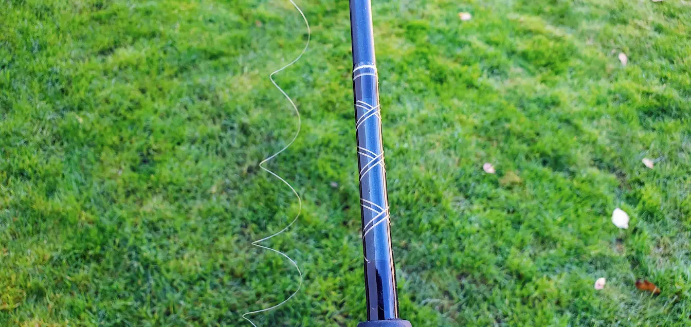 An image showing line memory. Fishing rod with curled fishing line from spool line memory.